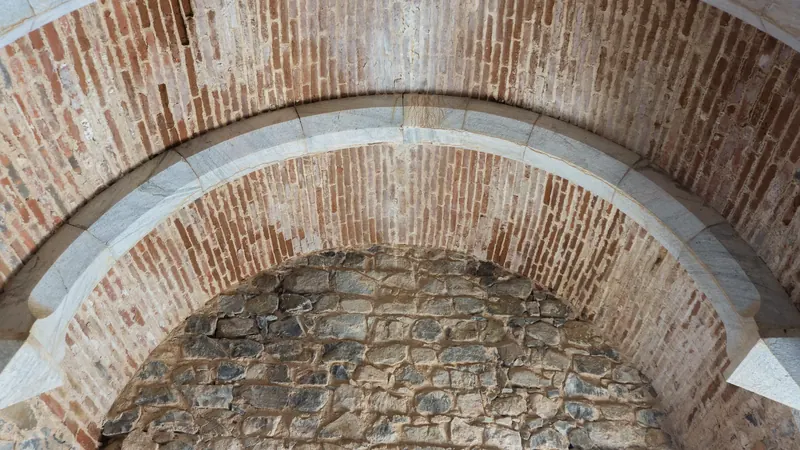 Brick and stone layers of an old arch in Beja